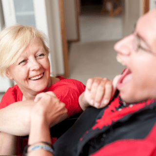 Care worker and resident laughing together.